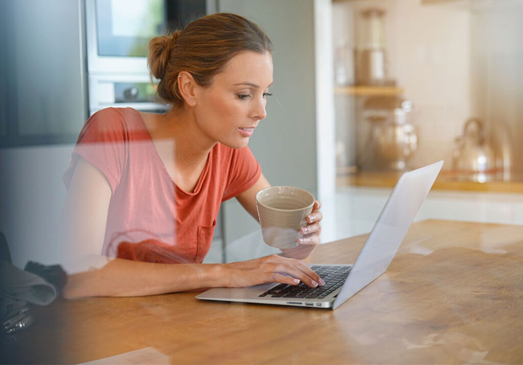 Femme utilisant son ordinateur portable pour rechercher des conseils afin de choisir un artisan fiable avant de signer un devis.