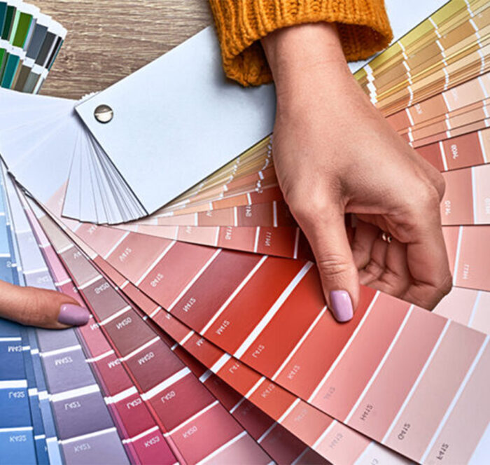 Nuanciers de couleurs RAL pour menuiseries tenus par des mains de femme