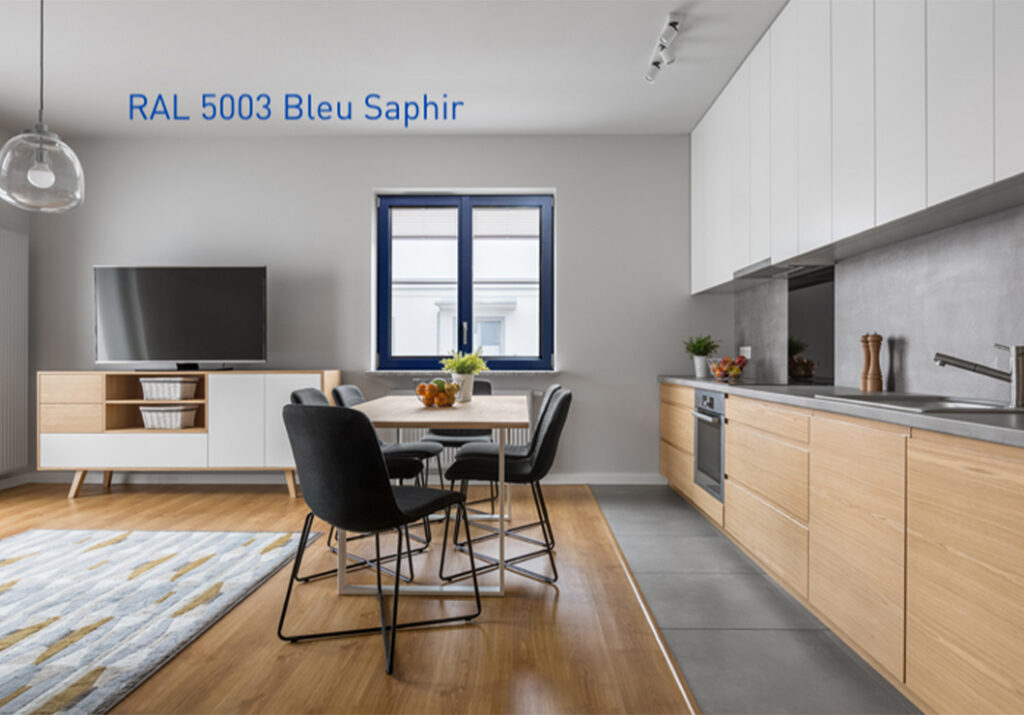 Cuisine ouverte sur un salon, aux tons bois, blanc et bleu, lumineuse grâce à une fenêtre en menuiserie bleu saphir, RAL 5003.
