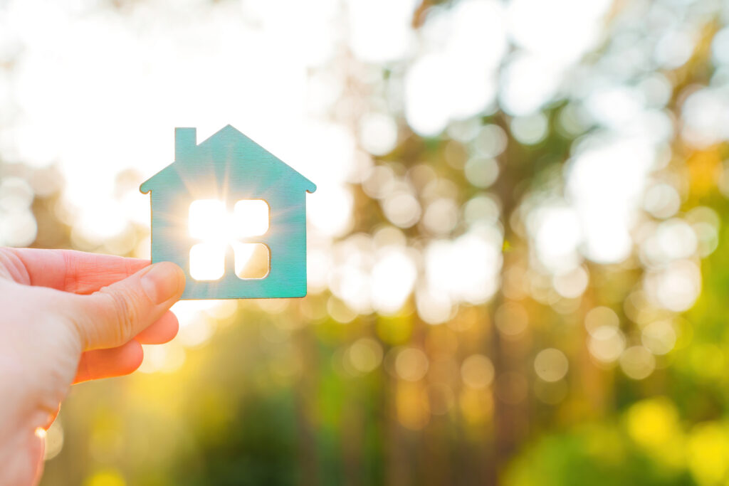Maison aux fenêtres illuminées par le soleil symbolisant la sérénité qu'apportent les garanties AMCC