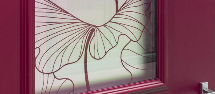 Zoom sur le détail d'une porte d'entrée Prestige AMCC de style classique de couleur rouge avec un vitrage décoratif imprimé