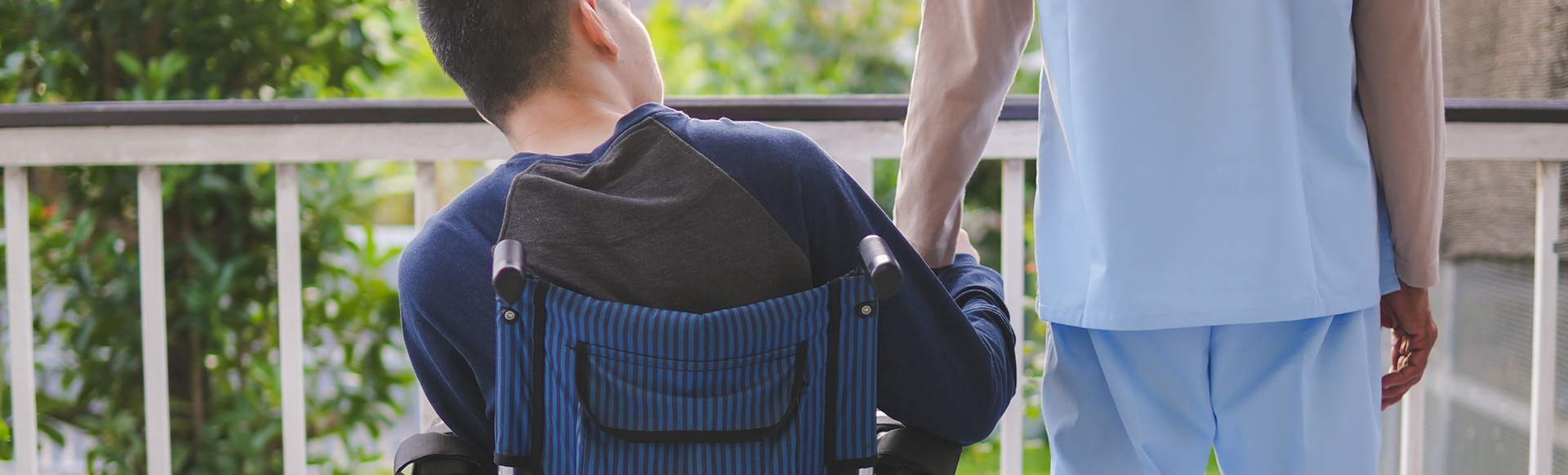 Homme en fauteuil roulant sur son balcon