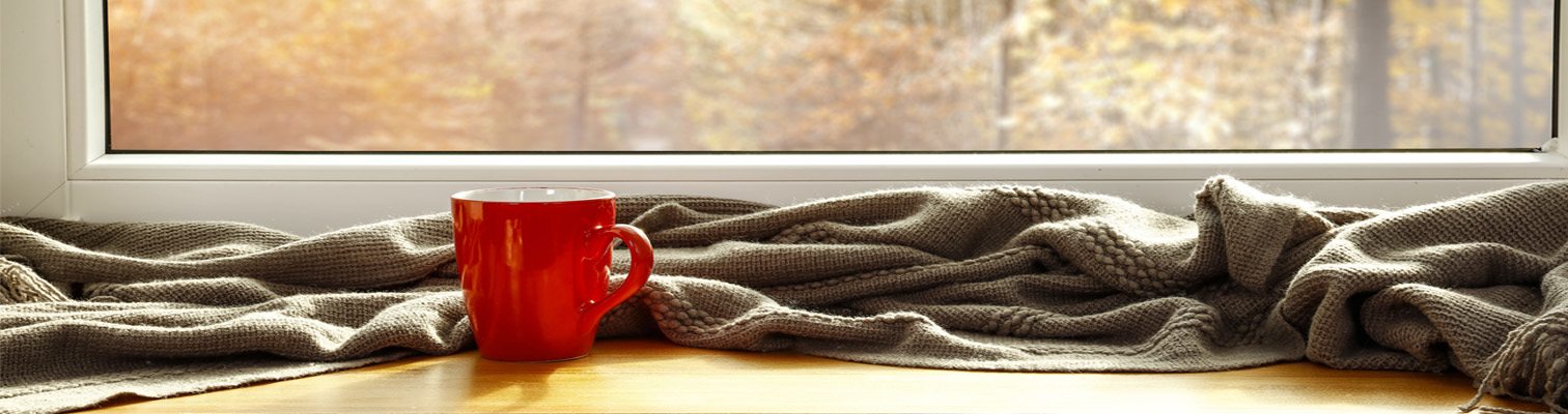 bord de fenêtres avec tablette en bois plaid et tasse de thé chaud pour le confort thermique et phonique avec les fenêtres amcc