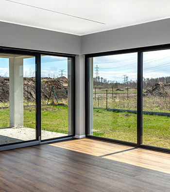 Baie vitrée noire avec vue sur un jardin verdoyant