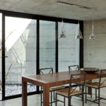 Baie vitrée coulissante noire dans une maison moderne en béton