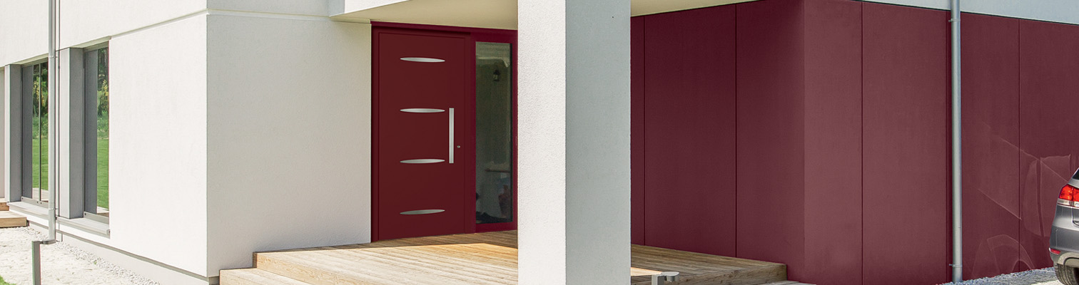 Zoom sur une façade de maison contemporaine avec une porte d'entrée aluminium pleine bordeaux Amcc