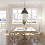 fenêtres blanches dans une salle à manger lumineuse vue sur des toits parisiens