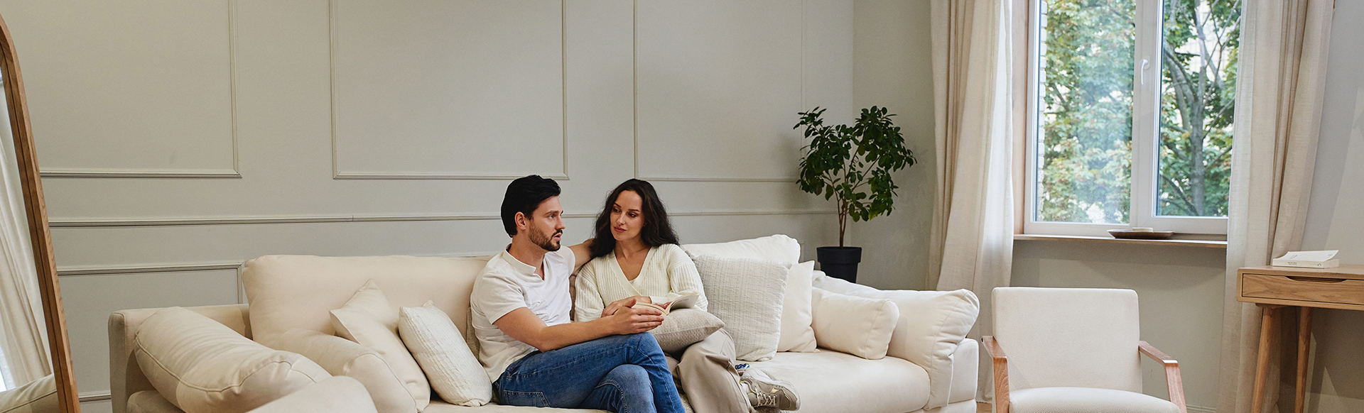 Couple sur un canapé devant une fenêtre PVC blanche
