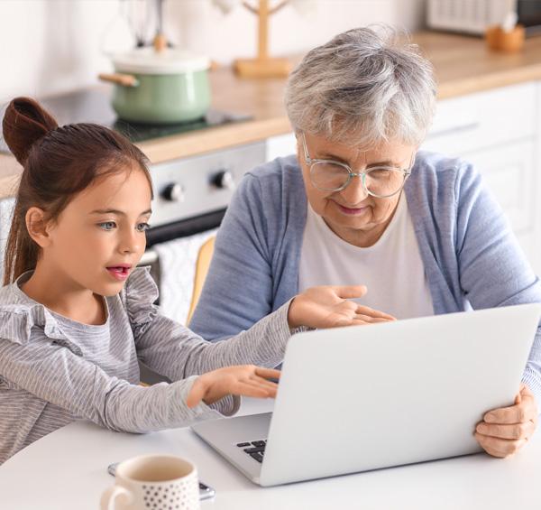 photo d'une grand-mère et sa petite-fille en train de regarder les portes d'entrée AMCC sur un ordinateur