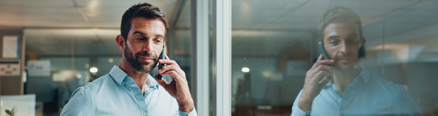 Homme en train d'écouter au téléphone les questions pour échanger sur un projet fenêtres et portes amcc