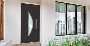 Vue extérieure d'une façade de maison actuelle avec une porte d'entrée sobre Prestige moderne partiellement vitrée AMCC