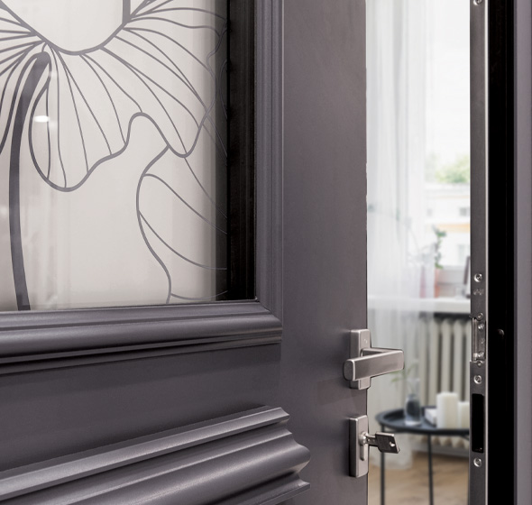 Zoom d'un détail de porte montrant un vitrage imprimé motif floral poignée béquille et moulure sur aluminium laqué classe 2 gris anthracite ral 7016porte d'entrée tradition Prestige AMCC