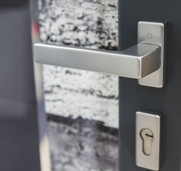 Zoom d'un détail de porte montrant un vitrage sérigraphié avec poignée béquille porte d'entrée contemporaine Prestige AMCC