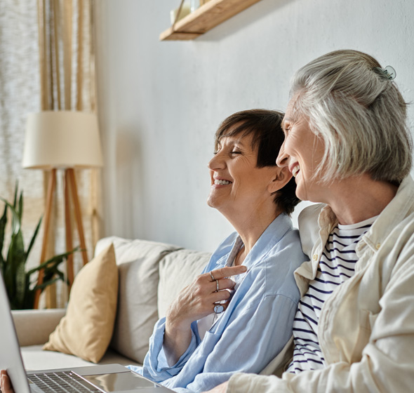Deux amies retraitées qui discutent et sourient en parlant de leur projet de travaux menuiseries