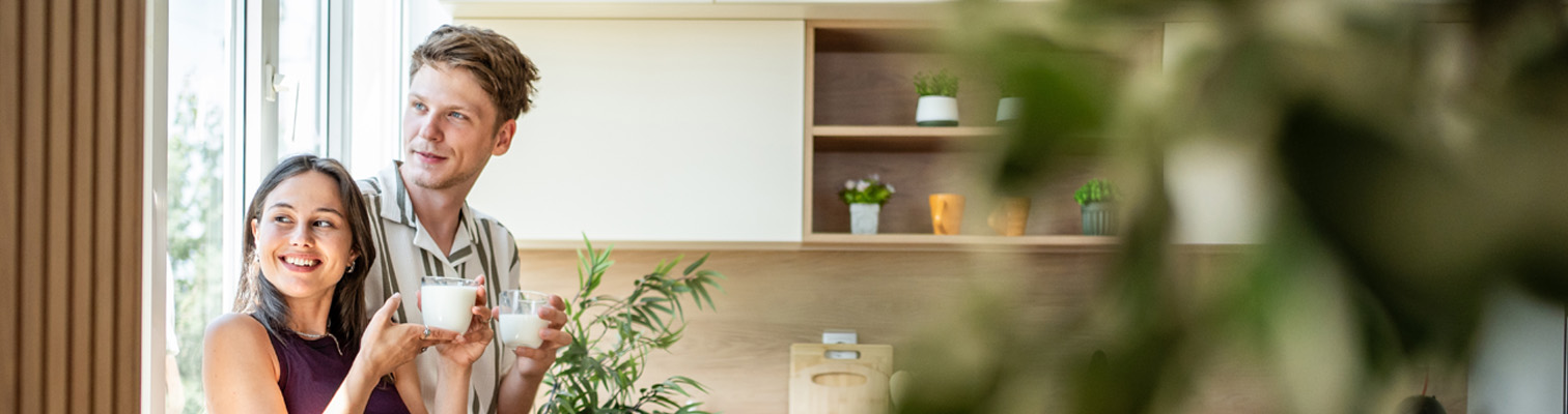 Jeune couple prenant le temps dans sa cuisine profitant de s nouvelle fenêtre pvc blanche