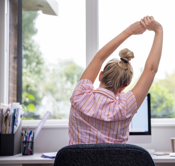 Jeune femme télétravaillant à la maison avec son bureau devant grande fenêtre pvc blanche