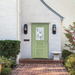 Porte d'entrée aluminium Leslie devant une façade de maison en briques blanches
