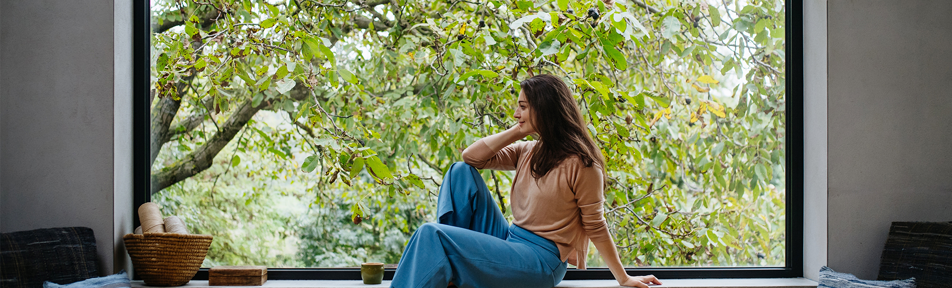 Femme devant une grande baie vitrée en aluminium