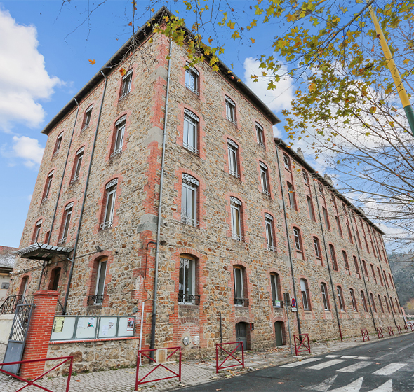 Vue extérieur d'un immeuble résidentiel au style industriel avec des fenêtres aluminium F78