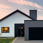Porte d’entrée Cadence associée à sa porte de garage, sur la façade avant d’une maison moderne.